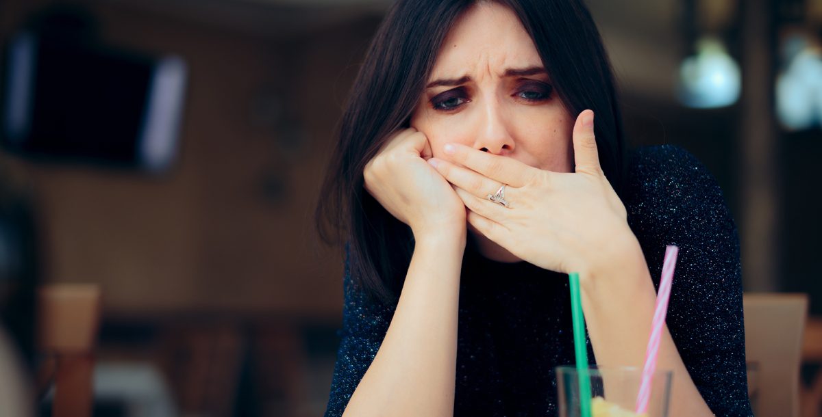 A woman experiencing hiccups while eating.
