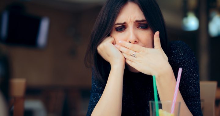 A woman experiencing hiccups while eating.